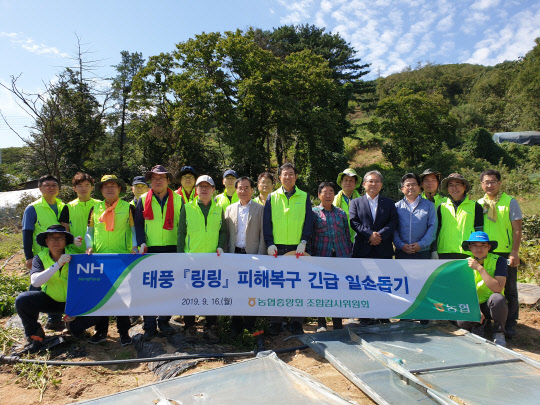 박규희 농협중앙회 조합감사위원장과 사무처 직원들이 16일 경기 양주시 어둔동에서 제13호 태풍 '링링' 피해복구 지원활동을 한 후 단체 기념촬영을 하고 있다.(사진=농협중앙회)